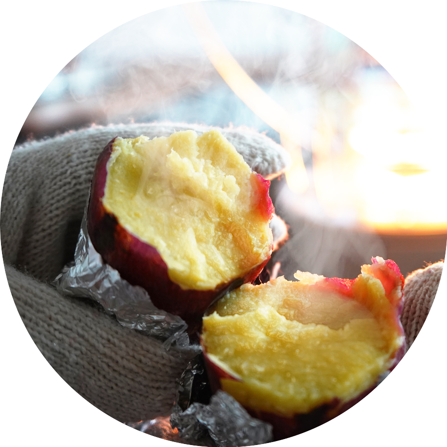 湯気の立つ焼き芋を頬張る手元